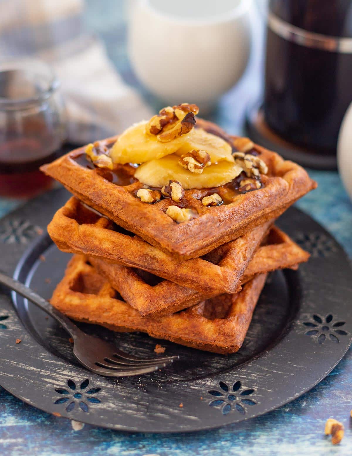 banana waffles topped with banana, nuts and syrup