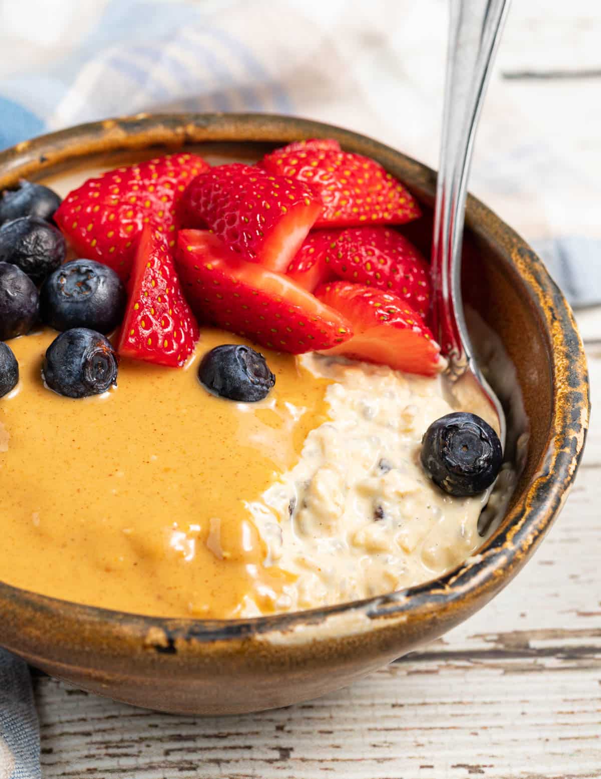 bircher muesli with sstrawberries, blueberries and peanut butter