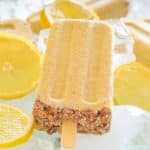 Creamy Lemon Cheesecake Pop surrounded by ice and slices lemons