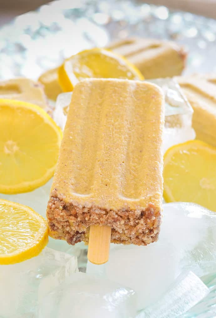 Creamy Lemon Cheesecake Pop surrounded by ice and slices lemons 