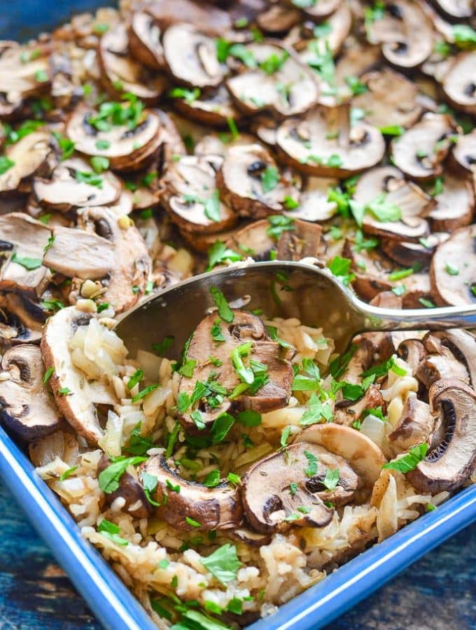 easy Oven Baked Garlic Mushroom Rice being served up with a spoon