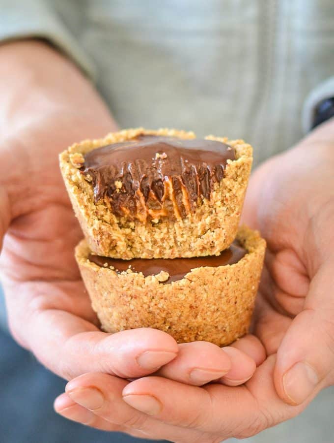 Healthier Chocolate Caramel Cookie Cups nestled in a man's hands