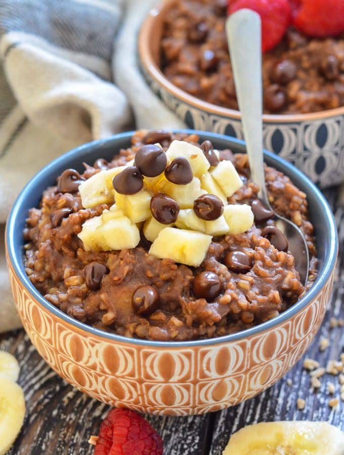 Healthy Chocolate Instant Pot Steel Cut Oats in a bowl, topped with a pile of chopped banana and chocolate chips.