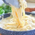 Skinny Fettuccine Cauliflower Alfredo in a pan with tongs lifting some out