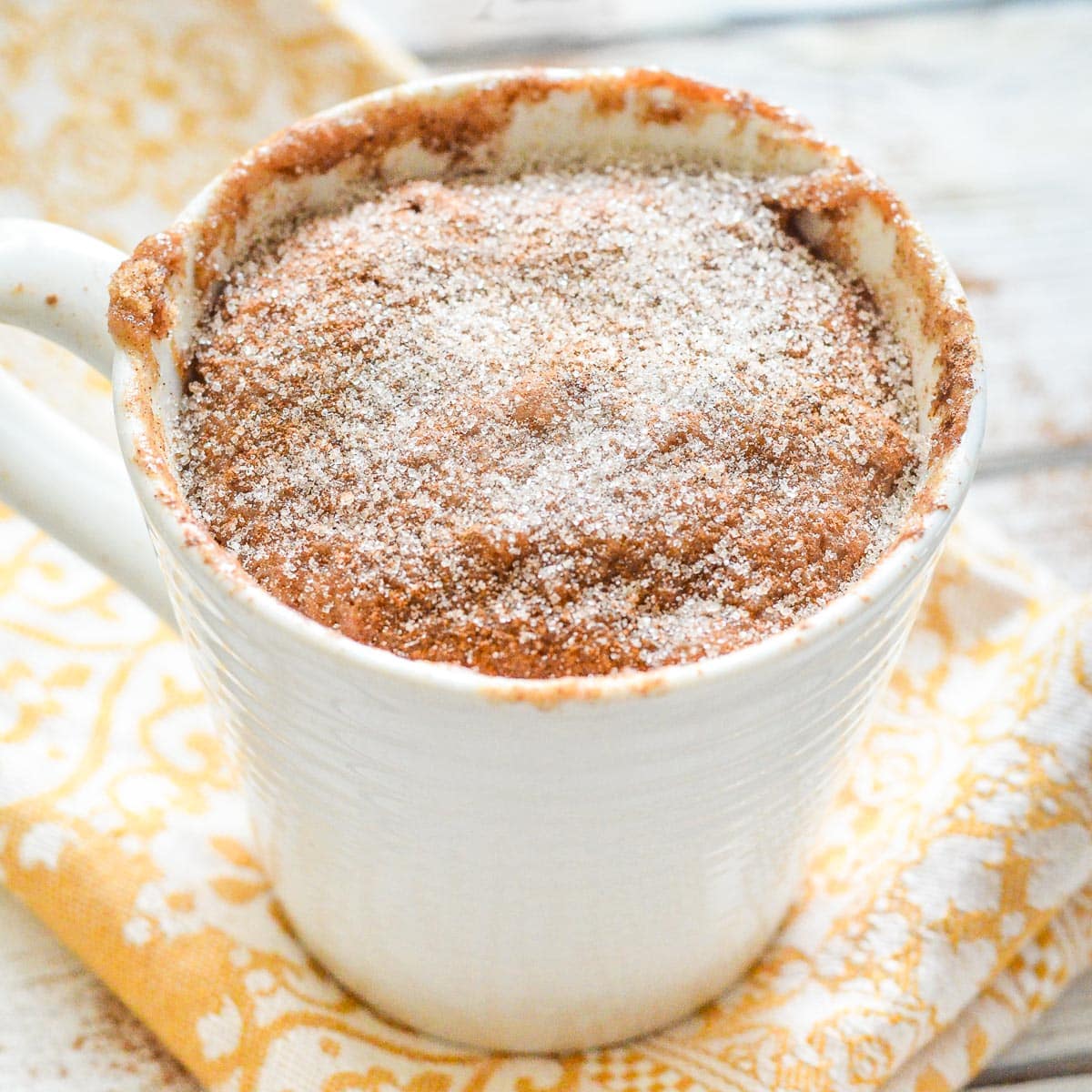 a snickerdoodle mug cake on a yellow napkin