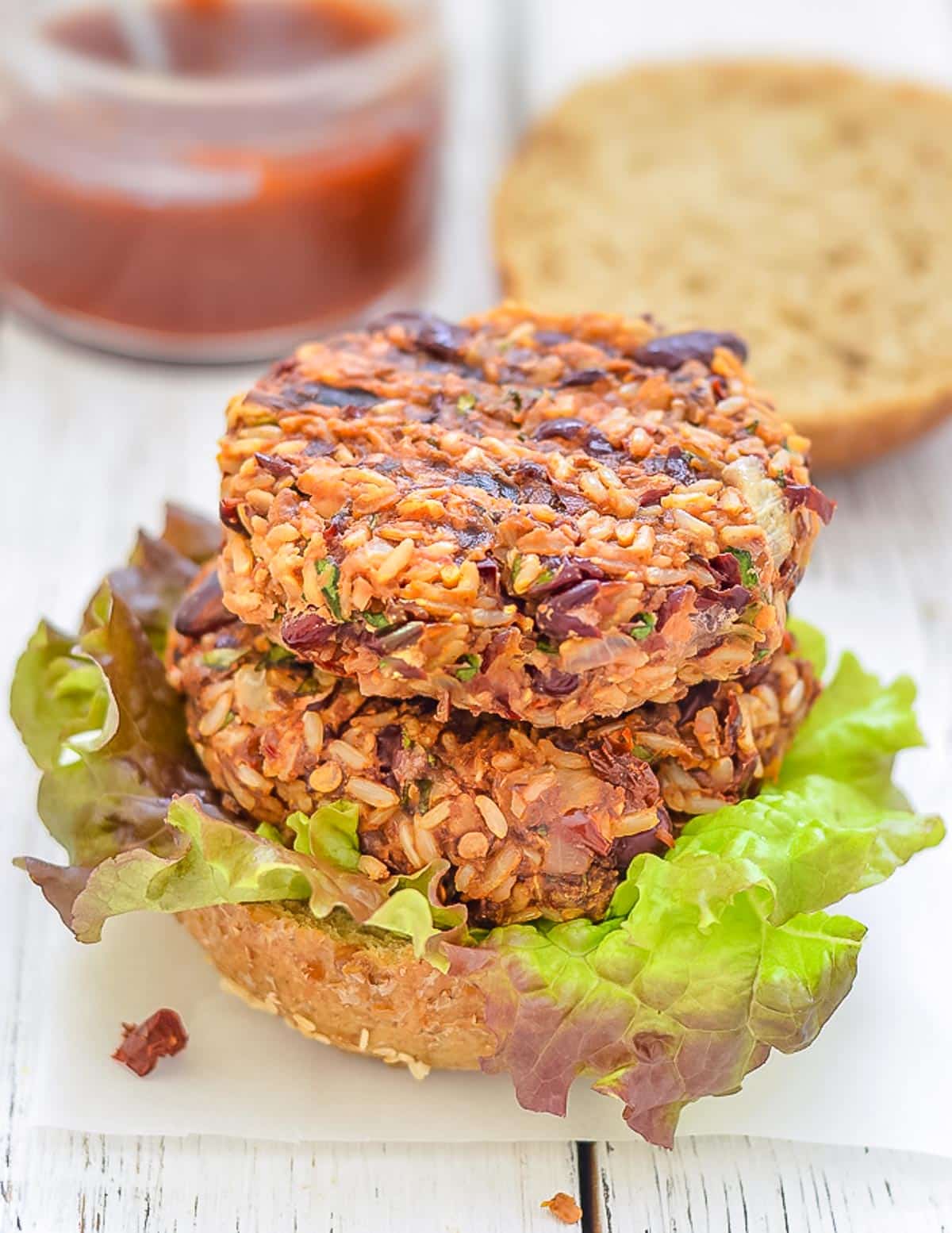 2 red bean and rice burgers stacked on a bun