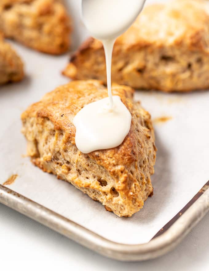 glaze being drizzled on a vegan banana scone