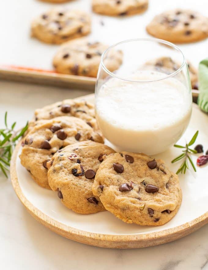 Vegan Chocolate Chip Cookies made festive with the addition of dried cranberries and rosemary! Soft, sweet, chewy, with a lovely subtle woodsy, herbal fragrance. Santa will thank you if you leave him a few of these with his glass of plant milk on Christmas Eve! 