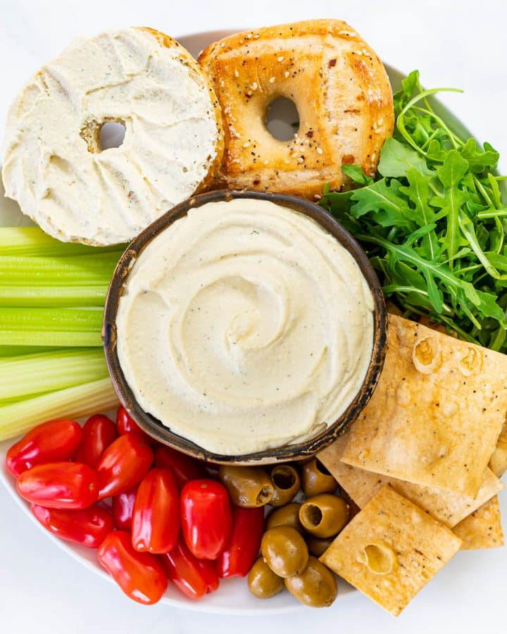 vegan cream cheese on a platter of crackers, bagels, veggies