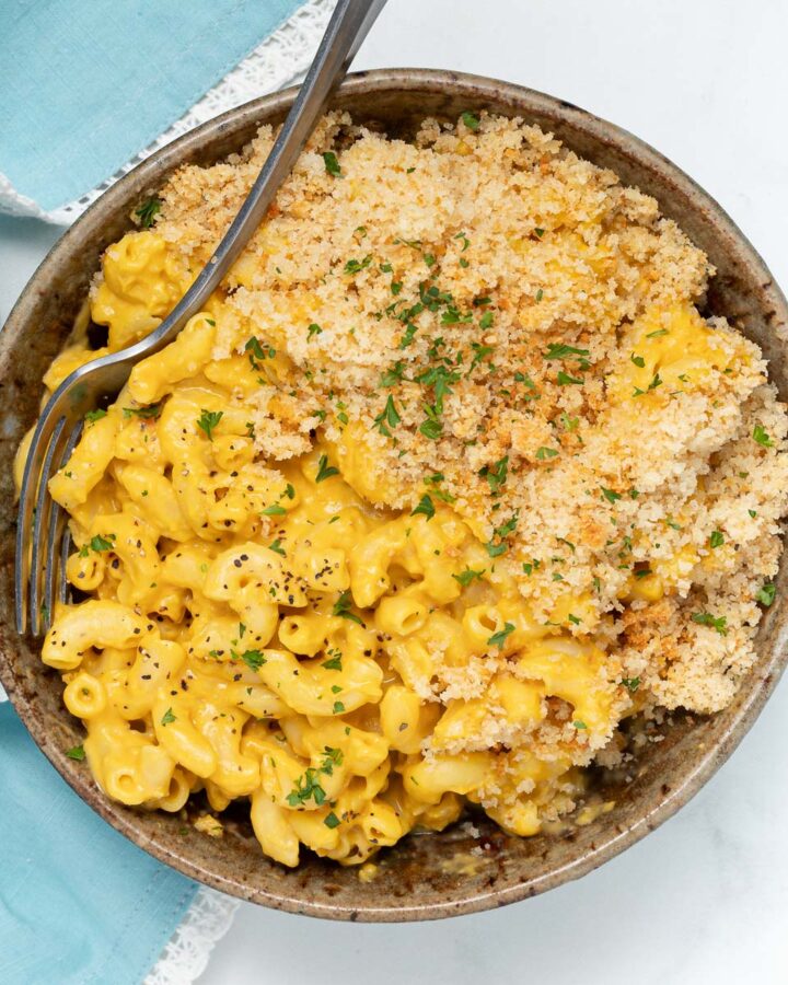 vegan mac and cheese in a bowl with a scattering of fresh parsley