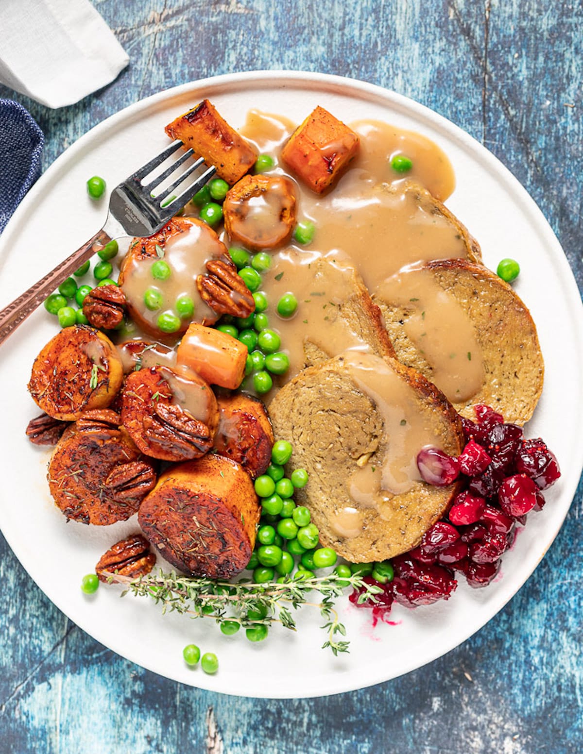 a vegan roast dinner, seitan, sweet potatoes, veg and cranberry sauce